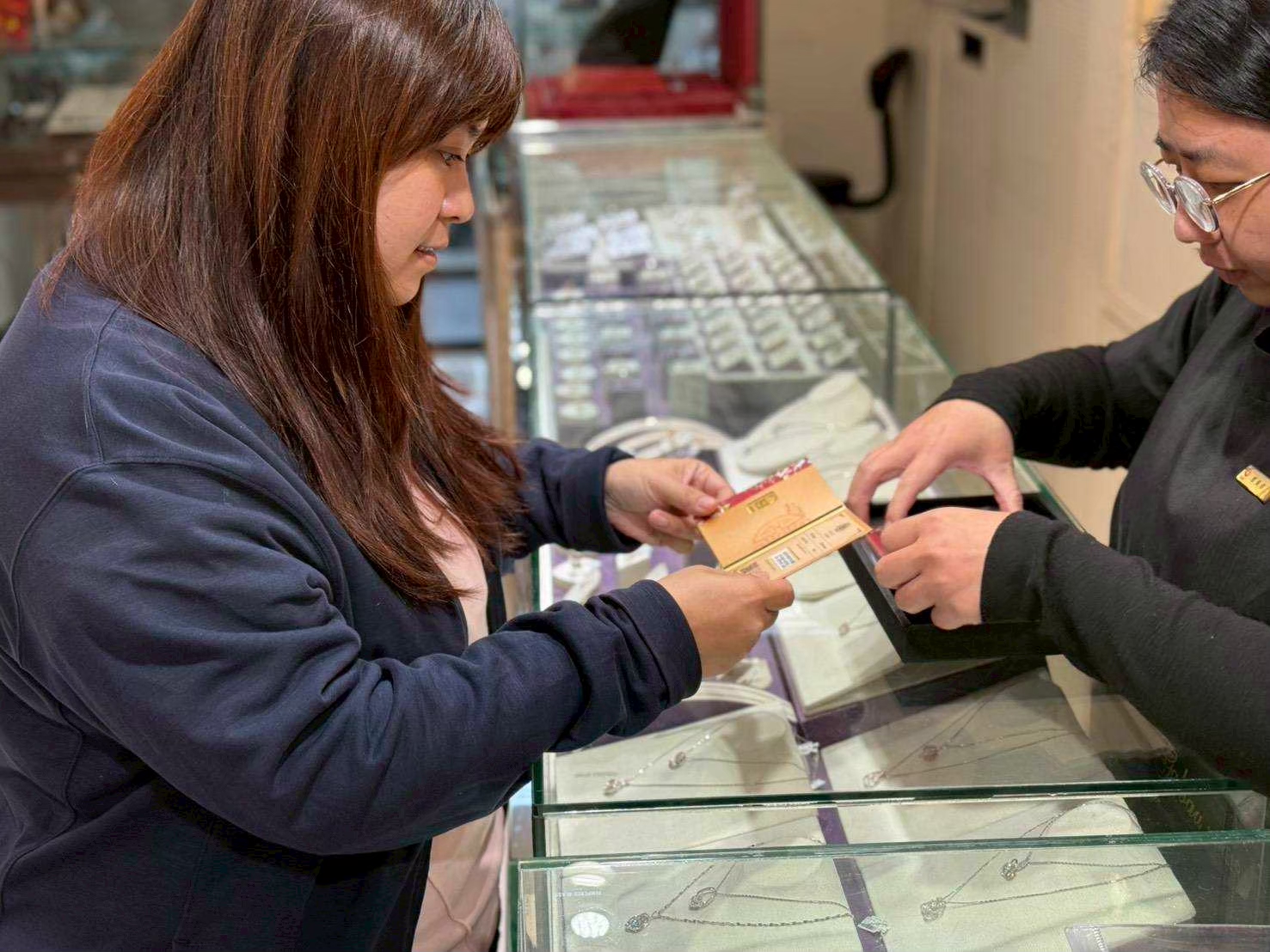 嘉寶珠寶交接黃金條塊與防偽卡冊過程