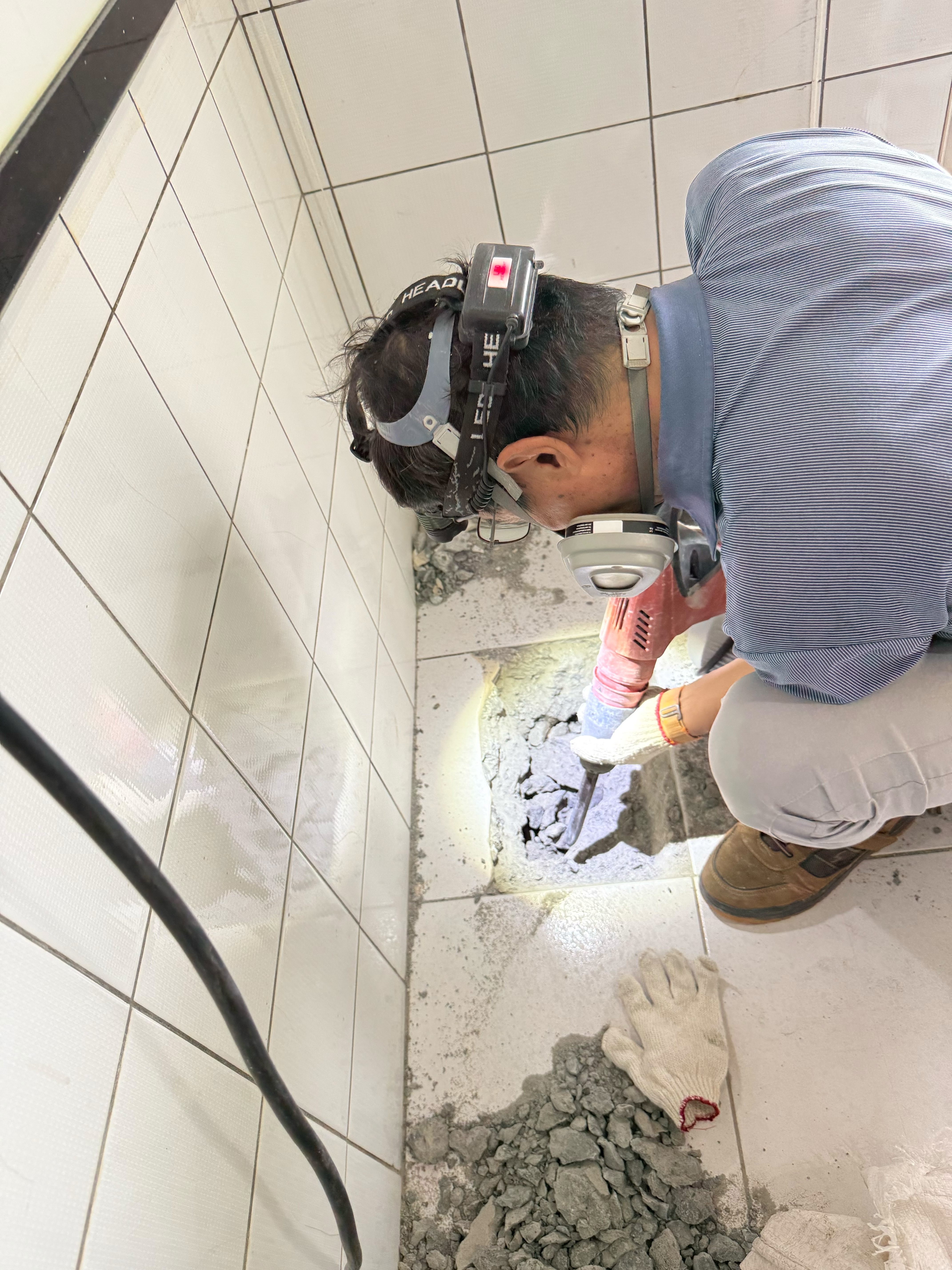 師傅以儀器檢測廚房地面滲水來源